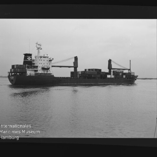Frachtschiff mit Deckskranen und gestapelten Containern fährt seitlich auf ruhiger See, Museumslogo unten links.