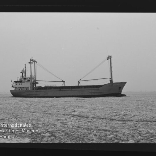 Frachtschiff mit zwei Ladekränen fährt durch eisbedecktes Wasser; Museumslogo und Schriftzug unten links.