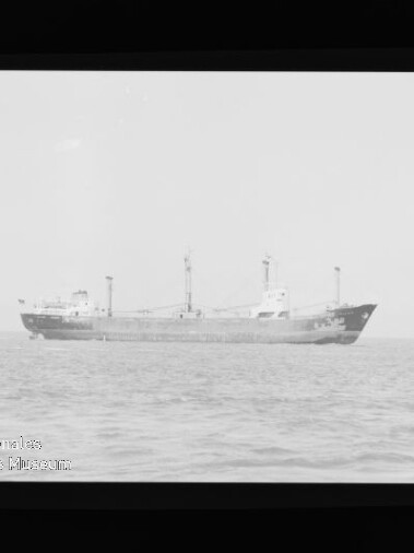 Seitenansicht eines Frachtschiffs auf ruhiger See; sichtbares Wasserzeichen: Internationales Maritimes Museum Hamburg.