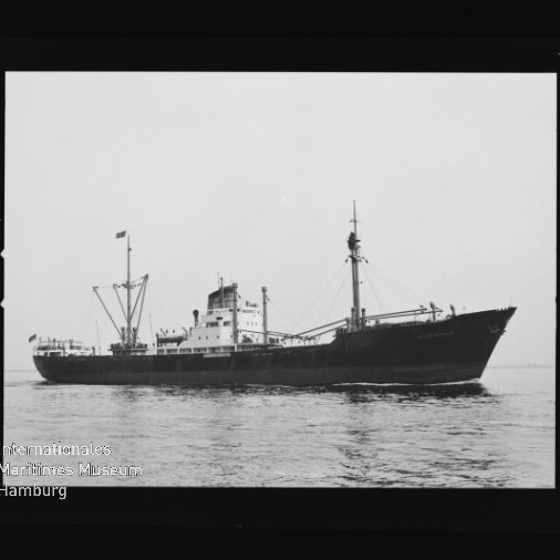 Seitliches Profil eines Frachtschiffs auf ruhiger See mit Masten, Ladebaum und Flagge; Museumslogo unten links