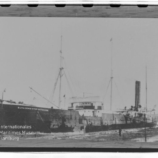 Gestrandetes Dampfschiff mit Schornstein und Masten; Name auf dem Rumpf und Museums‑Wasserzeichen sichtbar.