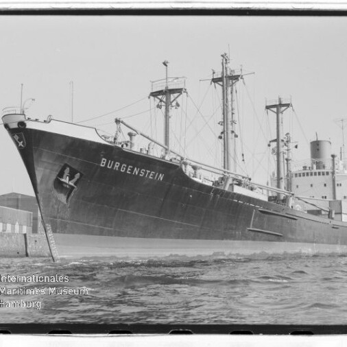 Frachtschiff BURGENSTEIN mit Kränen und Masten am Kai, Wellen im Vordergrund und Museumswasserzeichen unten links.