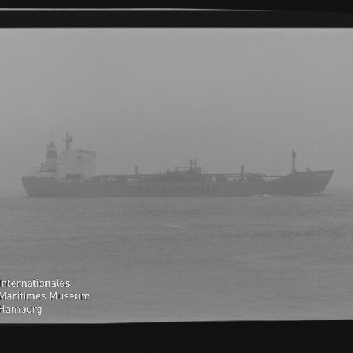 Nebeliger Frachter mit sichtbarem Schriftzug 'AMMONIAK' als Silhouette auf ruhiger See; Filmrand und Museumswasserzeichen.