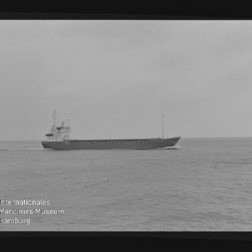 Schwarzweißaufnahme eines Frachtschiffs, das auf ruhiger See fährt; sichtbarer Filmrand mit Kodak Safety Film und Museumslogo.