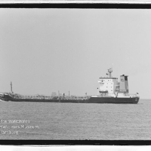 Langes Tankschiff mit achtern liegendem Aufbau auf ruhiger See, Museumslogo unten links.