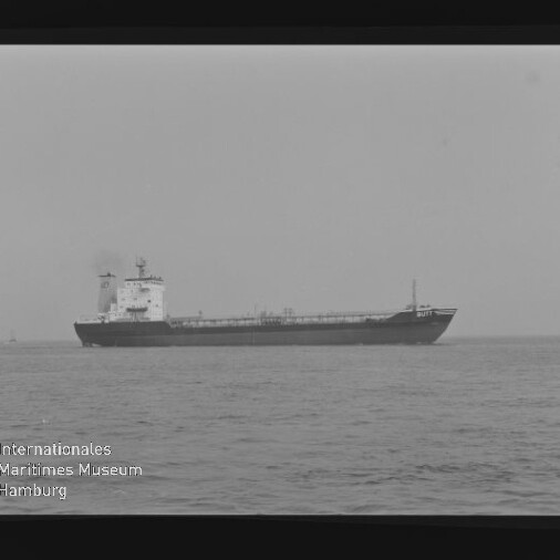 Seitenansicht eines Tankers auf ruhiger See in Schwarzweiß, mit Museumslogo und -schrift unten links.