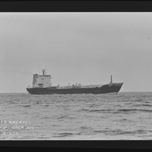 Schwarzweißaufnahme eines Frachtschiffs (Tanker) auf ruhiger See, mit sichtbarem Filmrand (AGFAPAN 100) und Museumswasserzeichen