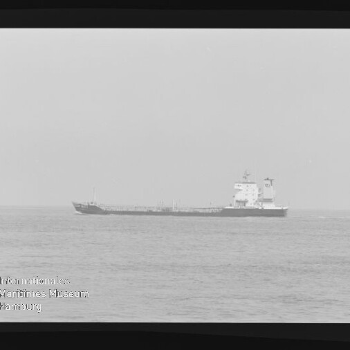 Schwarzweißaufnahme eines Tankschiffs in Seitenansicht auf ruhiger See, mit Filmrand und Stempel Internationales Maritimes Museum Hamburg.