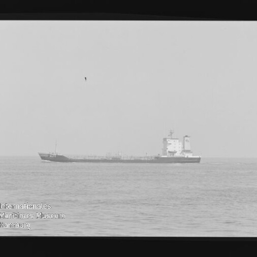Tankerschiff in der Ferne auf ruhiger See, sichtbarer schwarzer Filmrand und Wasserzeichen des Internationalen Maritimen Museums Hamburg.