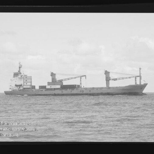 Frachtschiff mit zwei Ladekränen auf ruhiger See in s/w, mit schwarzem Negativrand und Wasserzeichen Maritimes Museum Hamburg.