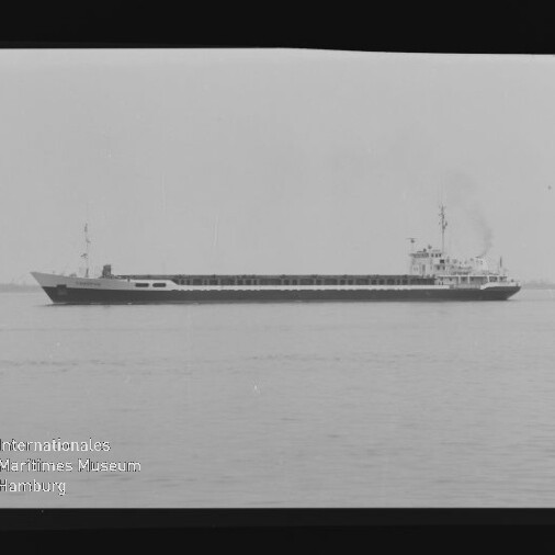 Langes Frachtschiff auf ruhiger See, schwarzweiß-Foto mit Internationales Maritimes Museum Hamburg Wasserzeichen unten links.