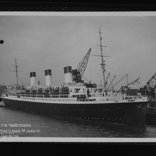 Großer Ozeandampfer mit drei Schornsteinen neben Kränen im Hafen; Schriftzug Internationales Maritimes Museum Hamburg links unten.