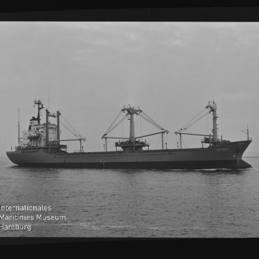 Schwarzweißaufnahme eines Frachtschiffs mit drei Lademasten und Kränen auf ruhiger See; Schriftzug Internationales Maritimes Museum Hamburg unten links