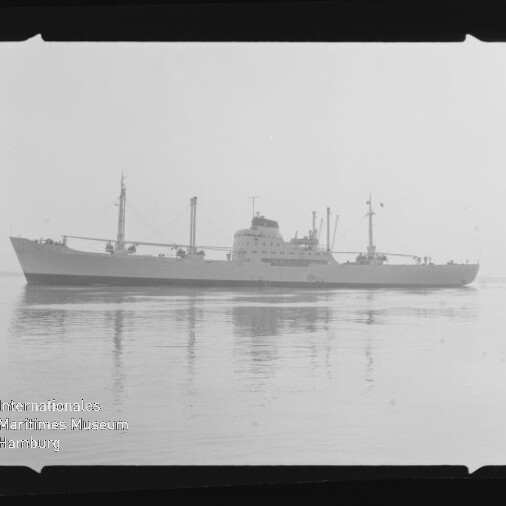 Seitenansicht eines Frachtschiffs auf ruhiger See mit Spiegelung und Wasserzeichen des Maritimen Museums Hamburg unten links.