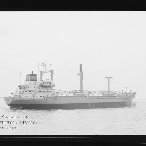 Schwarzweißaufnahme eines Frachtschiffs mit zwei Masten und Ladekränen auf ruhiger See, Wasserzeichen des Internationalen Maritimen Museums Hamburg