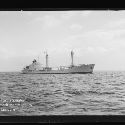 Schwarzweißaufnahme eines Frachtschiffs mit zwei Masten auf ruhiger See, Wasserzeichen Internationales Maritimes Museum Hamburg.