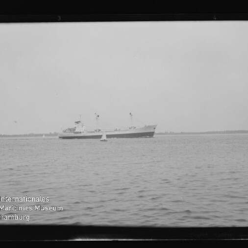 Schiff mit zwei Masten auf ruhigem Meer vor flachem Horizont, Boje im Vordergrund und Museumssiegel unten links.