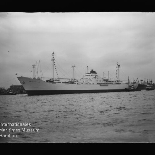 Großes Schiff im Hafen neben Schleppern, welliges Wasser und bewölkter Himmel; Logo Maritimes Museum Hamburg