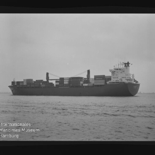 Containerschiff in Seitenansicht mit Containern und Kränen auf ruhiger See; Filmrand zeigt AGFA APX 100 und Museumslogo.