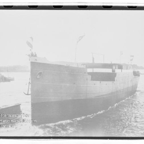 Bugansicht eines Frachtschiffs mit Flaggen auf ruhigem Wasser, schwarzweißes Archivfoto