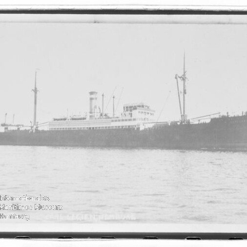Großes dampfgetriebenes Frachtschiff mit Schornstein und Ladebäumen, seitliche Ansicht auf ruhiger See.