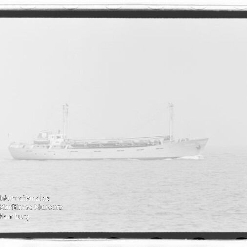 Frachtschiff mit zwei Masten auf ruhiger See, schwaches Wasserzeichen unten links.