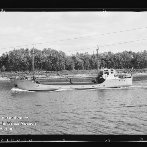 Schwarzweißfoto eines kleinen Frachtschiffs, fahrend auf einem Kanal, Baumreihe am Ufer und Museumsemblem unten links