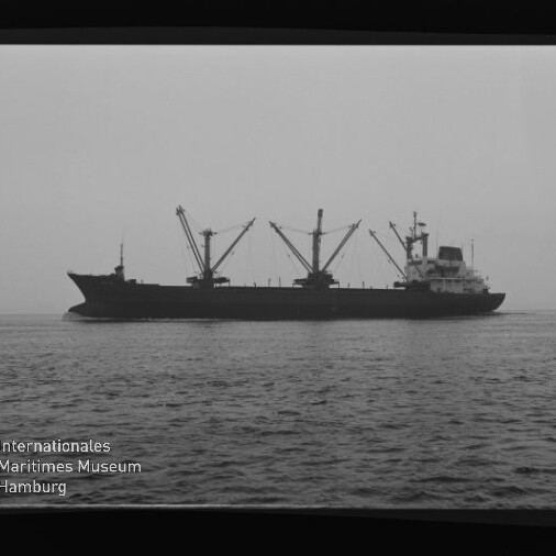 Frachtschiff mit mehreren Ladekränen in Seitenansicht auf ruhiger See, Schwarzweißaufnahme mit Museumslogo.
