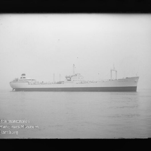 Schwarzweiß-Seitenansicht eines großen Frachtschiffs auf ruhiger See, mit Wasserzeichen Internationales Maritimes Museum Hamburg.