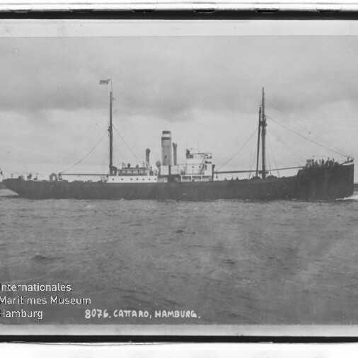 Schwarzweiß-Foto eines historischen Dampfschiffs mit Schornstein und Masten auf ruhiger See, Text 
