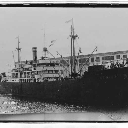 Dampfschiff mit Schornstein und Masten am Kai vor Lagerhaus; Wasserzeichen: Maritimes Museum Hamburg