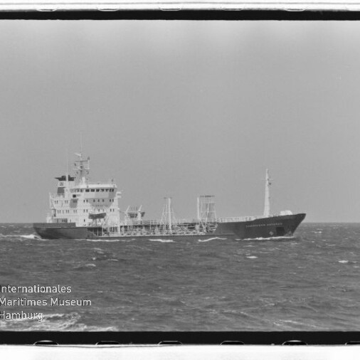 Schwarzweißaufnahme eines Tankschiffs auf leicht bewegter See, mit Rahmen und Schriftzug 