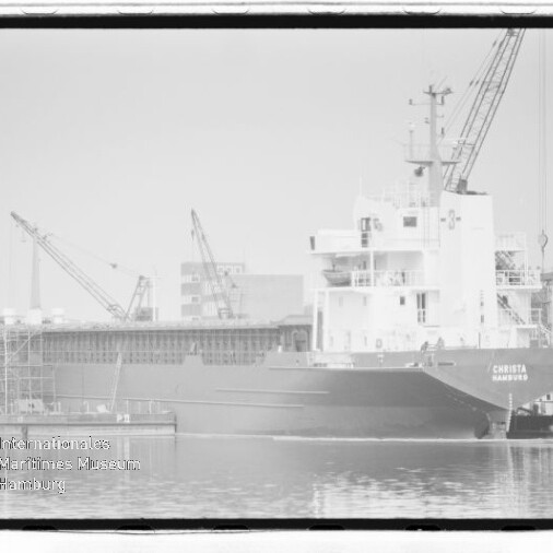 Frachtschiff CHRISTA (Hamburg) am Industriehafen, Kaje mit Kränen und Lagergebäuden im Hintergrund.