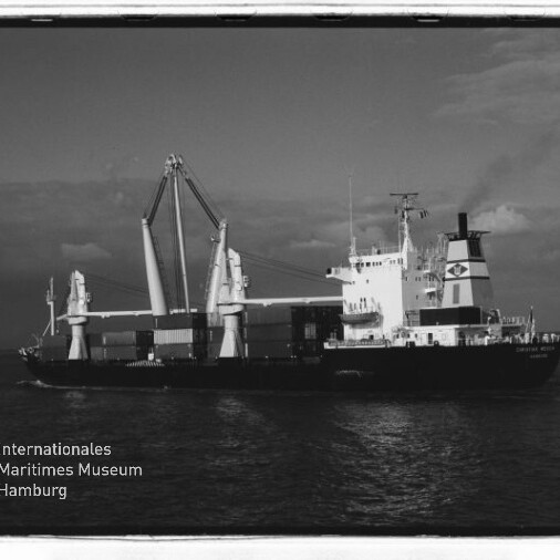 SW-Foto eines Frachtschiffs mit Ladekränen und Containern auf See; links unten Wasserzeichen Maritimes Museum Hamburg