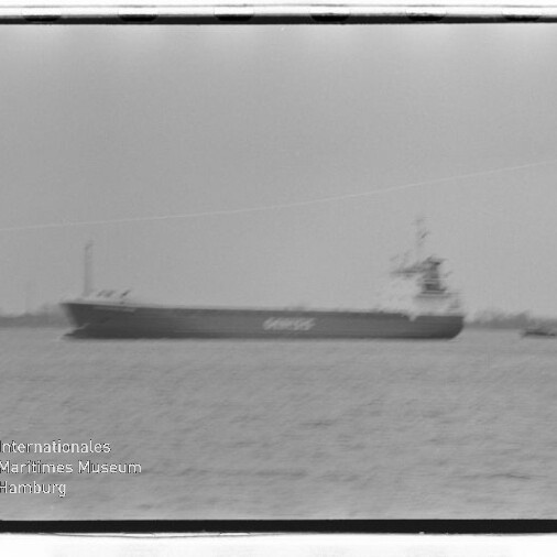 Großes Frachtschiff auf ruhigem Wasser, unscharf, mit Wasserzeichen Internationales Maritimes Museum Hamburg unten links.