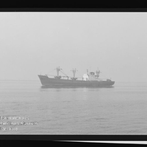 Schwarzweißfoto eines Frachtschiffs mit Ladekränen auf ruhiger See, sichtbarer Filmrand mit KODAK-Schriftzug und Museumslogo.