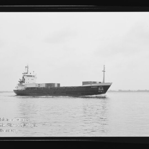 Containerschiff fährt auf ruhigem Wasser; Schwarzweißaufnahme mit Museumslogo unten links.