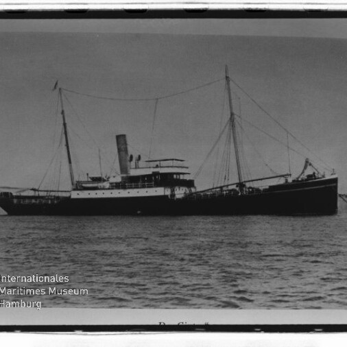 Historisches Schwarzweißfoto eines vorm Anker liegenden Dampfschiffs mit Schornstein und zwei Masten; Museumsstempel links unten.
