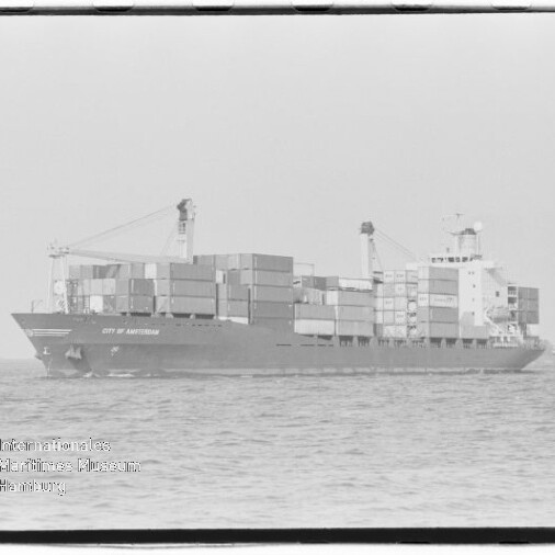 Containerschiff City of Amsterdam mit aufgestapelten Ladungskontainern und zwei Ladekränen auf ruhiger See.