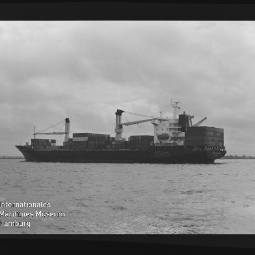 Containerschiff mit gestapelten Containern und Kränen auf ruhiger See, bewölkter Himmel; Museumslogo unten links.