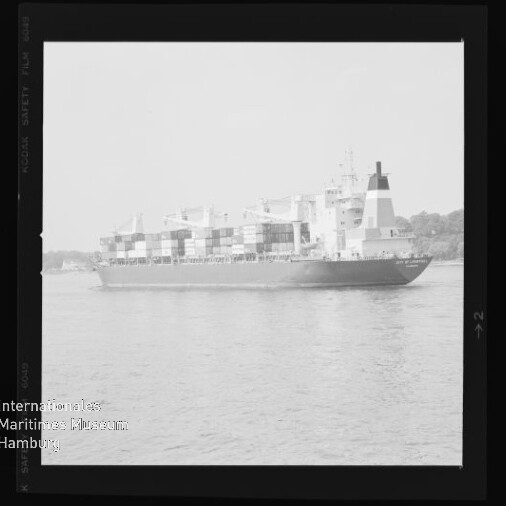 Schwarzweißfoto eines Containerschiffs auf ruhigem Wasser mit Wasserzeichen 'Internationales Maritimes Museum Hamburg'.