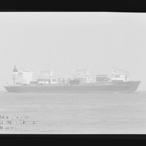 Frachtschiff mit Ladekränen seitlich auf ruhiger See, sichtbarer Negativ-Filmrand und Wasserzeichen des Maritimen Museums Hamburg.