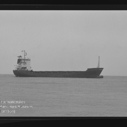Frachtschiff in Seitenansicht auf ruhiger See, Schwarzweiß-Aufnahme mit sichtbarem AGFA PAN 100-Filmrand und Museumslogo.