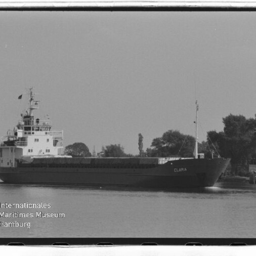 Frachtschiff CLARA auf einem Kanal vor baumbewachsenem Ufer, schwarzweiß-Aufnahme mit Museumslogo unten links.