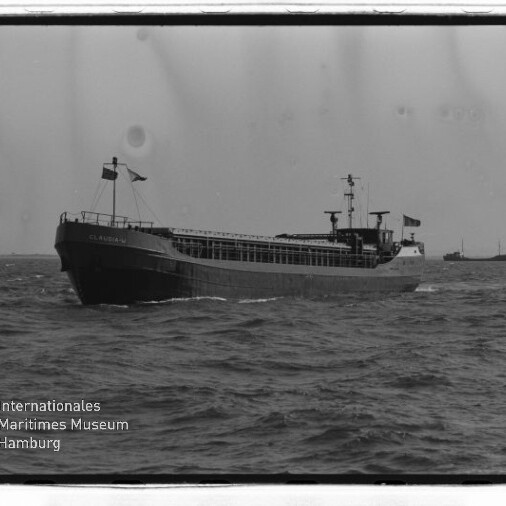Frachtschiff auf offener See mit weiterem Schiff am Horizont; unten links Logo des Internationalen Maritimen Museums Hamburg.