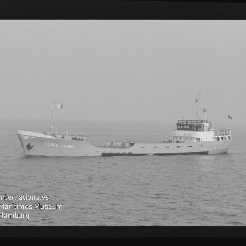 Küstenfrachtschiff mit aufgesetzter Brücke und Namen am Bug, das ruhig über die offene See fährt.