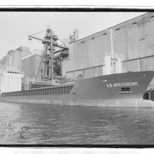 Frachtschiff K.B. AMSTERDAM angelegt am Industriehafen vor großen Silos und Ladekranen