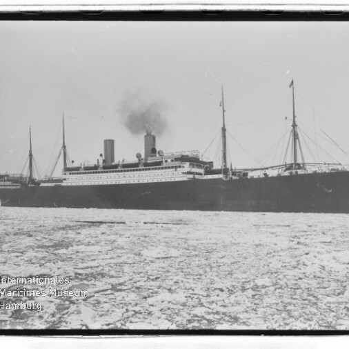 Historisches Dampfschiff mit schwarzem Rumpf und rauchender Schornstein fährt durch eisbedecktes Meer; Museumslogo unten links.