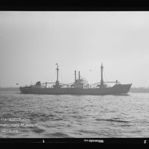 Frachtschiff mit zwei Masten und Ladebäumen auf ruhiger See, Wasserzeichen des Internationalen Maritimen Museums Hamburg.