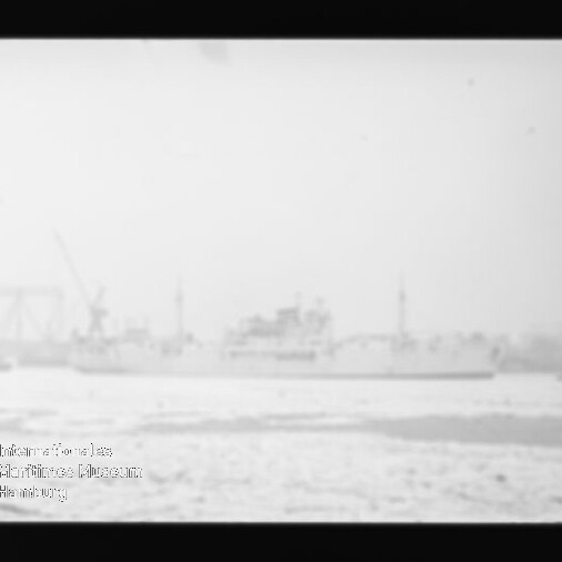 Verschwommenes Schwarzweißbild eines großen Schiffs im Hafen vor Kränen, mit Wasser im Vordergrund und Museumslogo links unten.